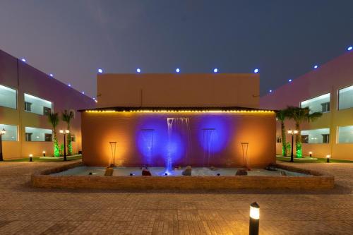 a fountain in front of a building at night at شقق قصر الممشى للوحدات السكنية in Jazan
