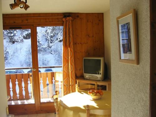 Cette chambre dispose d'une fenêtre, d'une télévision et d'une table. dans l'établissement Appartement de standing au pied des pistes, à Morzine