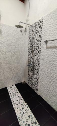 a bathroom with a shower with a black and white floor at Jungle view one bedroom apartment in Unawatuna