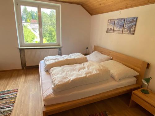 a bedroom with two beds with white sheets and a window at Haus Roith in Ebensee