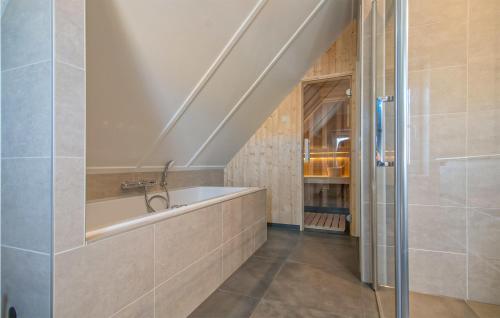 ein Badezimmer mit einem Waschbecken und einer Badewanne in der Unterkunft Cozy Home In Den Ham With Kitchen in Den Ham
