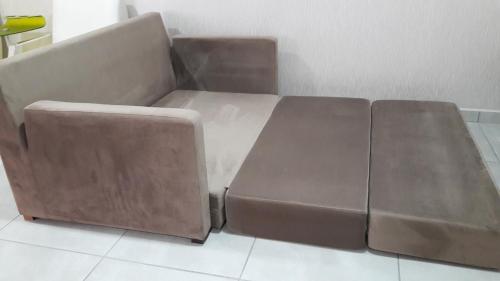 a brown couch sitting in a living room at Ap flat central- ar, garagem e ótima localização in Foz do Iguaçu