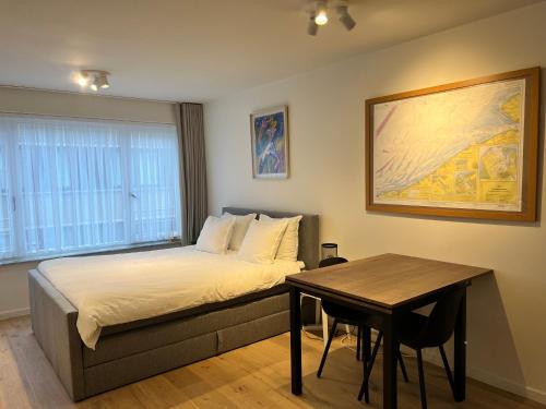 um pequeno quarto com uma cama e uma mesa em Cosy Studio Testerep , Newly Renovated em Oostende