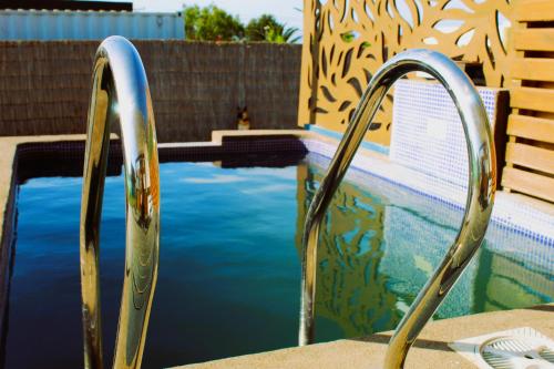 a swimming pool with a pair of metal hand rails at WANNAQUEROS SUITES in Guanaqueros