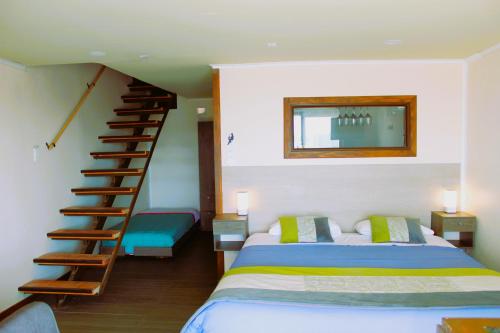 a bedroom with a bed and a spiral staircase at WANNAQUEROS SUITES in Guanaqueros