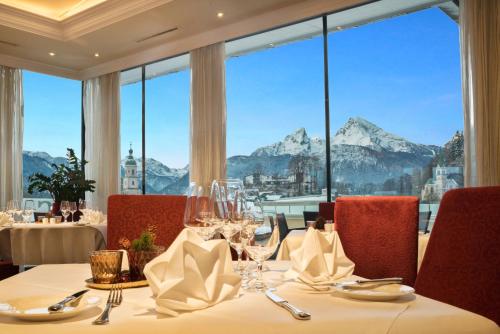 a dining room with a table with a view of mountains at Hotel EDELWEISS Berchtesgaden Superior in Berchtesgaden