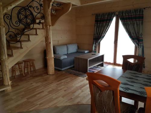 uma sala de estar com um sofá e uma escada em U Garczków em Witów
