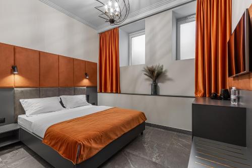 a bedroom with a large bed with orange curtains at Kievinn in Kyiv