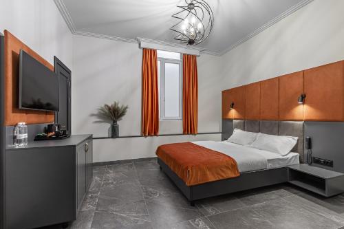 a bedroom with a bed and a flat screen tv at Kievinn in Kyiv