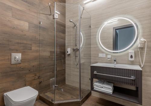 a bathroom with a shower and a toilet and a mirror at Kievinn in Kyiv