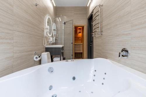 een badkamer met een wit bad en een wastafel bij Kievinn in Kiev