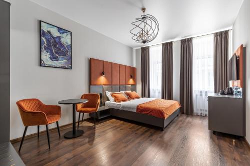 a hotel room with a bed and a table and chairs at Kievinn in Kyiv
