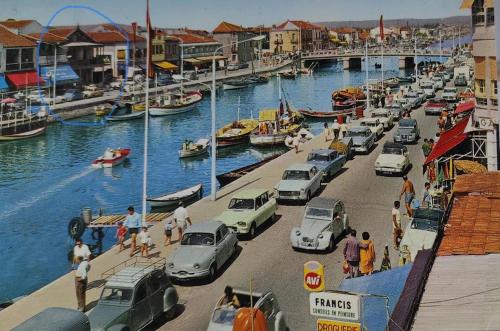 a group of cars parked next to a marina with boats at Hôtel les 4 éléments in Palavas-les-Flots