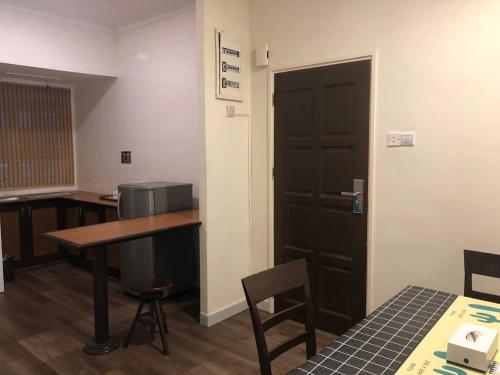 a room with a table and a door and a table and chairs at Perdana Serviced Apartment & Resorts in Kampung Padang Masirat