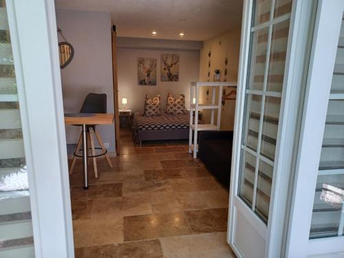 a hallway with a room with a couch and a table at Le gîte Calluna in Sablet
