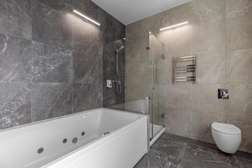 a bathroom with a bath tub and a toilet at Kievinn in Kyiv