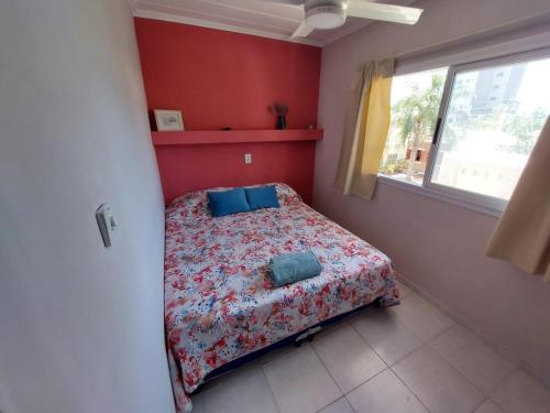 Un dormitorio con una cama con almohadas azules. en Departamento practico, con buena iluminación y ubicación. en Paraná
