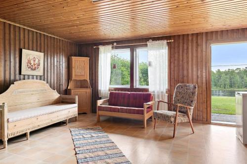 a bedroom with a bed and a couch and a chair at Stadsnära och naturskön villa med 50m till vatten in Granträsket