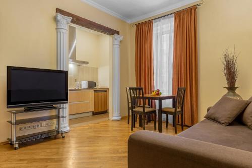 a living room with a television and a table with chairs at Kievinn in Kyiv
