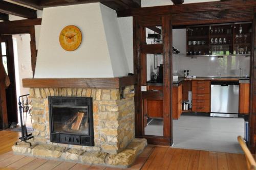 a stone fireplace with a clock on top of it at Villa sous le Tilleul in Barr