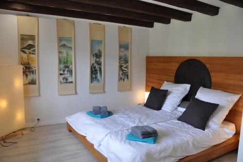 two beds in a room with paintings on the wall at Villa sous le Tilleul in Barr