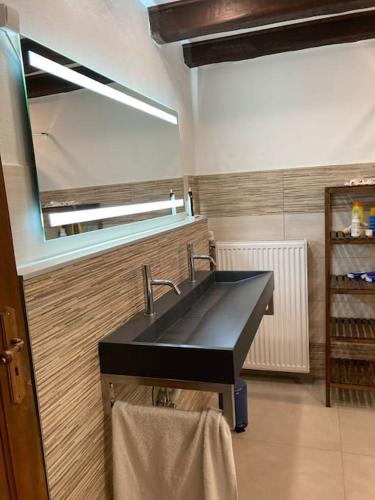 une salle de bain avec un lavabo noir et un miroir dans l'établissement Villa sous le Tilleul, à Barr