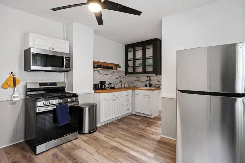 a kitchen with white cabinets and a black refrigerator at Center of Little Italy #4 in Cleveland