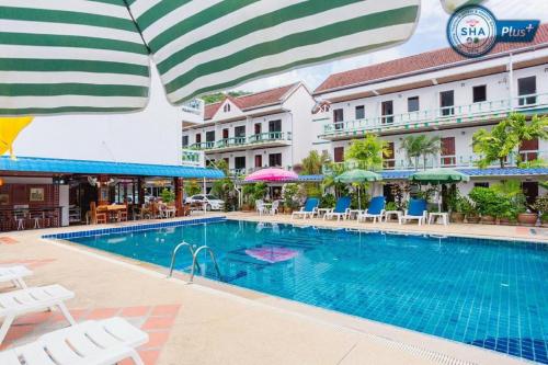 a pool at a hotel with chairs and umbrellas at Rabbit Mansion Patong - SHA Plus in Patong Beach