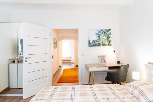 1 dormitorio con 1 cama y escritorio con silla en Dana's Apartment beim Augarten, en Viena
