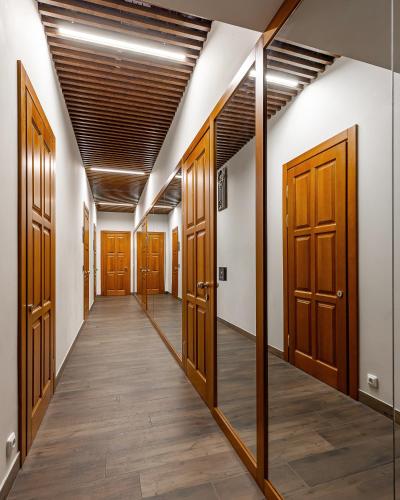 a hallway with wooden doors and wood floors at Kievinn in Kyiv