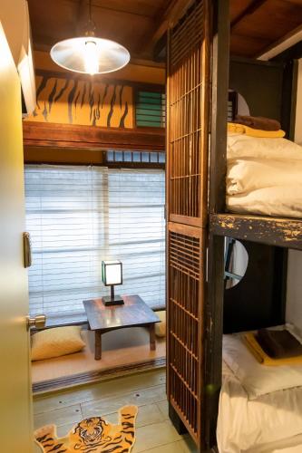 a room with bunk beds and a table with a lamp at Villa Sacra in Kamakura