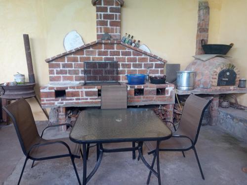 einen Tisch und Stühle vor einem Steinofen in der Unterkunft La casa de las flores in Zacatlán