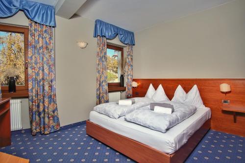 a bedroom with a bed in a room with a window at PanoramaHotel Penegal in Mendola