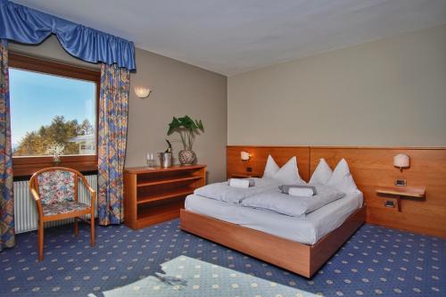 A bed or beds in a room at PanoramaHotel Penegal