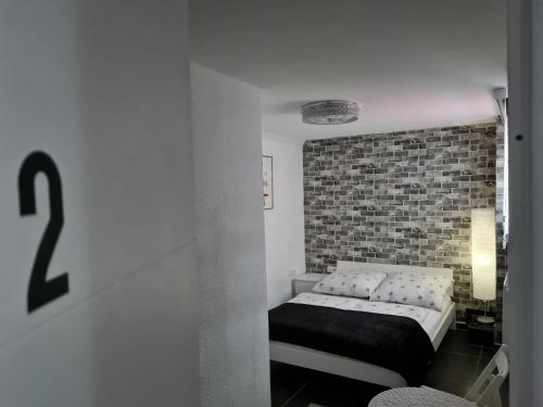 a bedroom with a bed and a brick wall at Roggendorf Zimmervermietung in Roggendorf