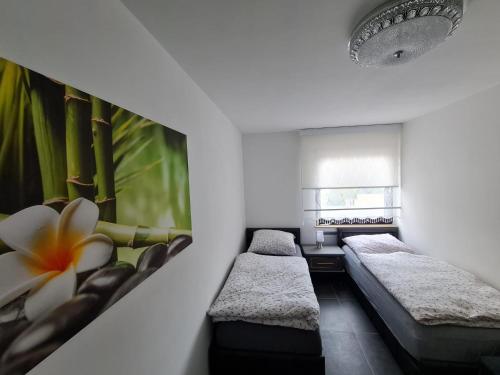 a room with two beds and a flower on the wall at Roggendorf Zimmervermietung in Roggendorf