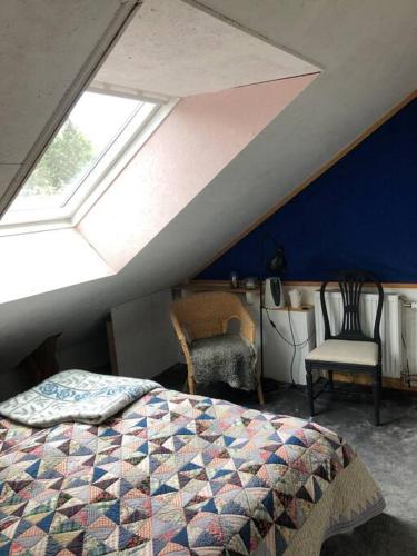 a attic bedroom with a bed and a window at Mysigt men trångt vindsrum i Svinaberga! in Kivik