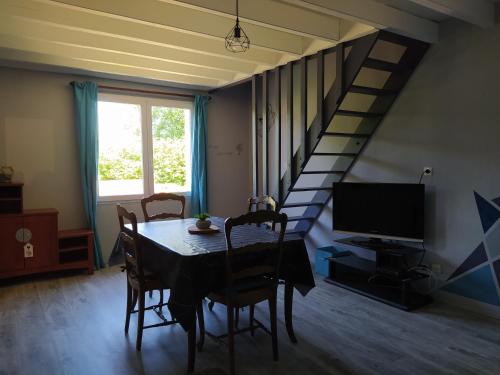 a dining room with a table and a staircase at Les gîtes de Vensac in Vensac