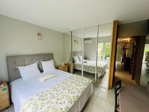 een slaapkamer met een groot bed en een spiegel bij Paradise in Le Gosier