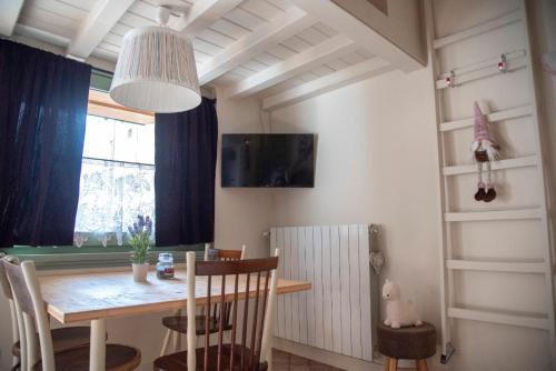 jadalnia ze stołem i oknem w obiekcie Maison Lume w mieście Ponte di Legno