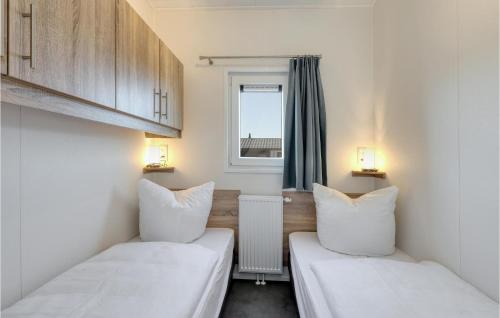 2 Betten in einem kleinen Zimmer mit Fenster in der Unterkunft 2 Bedroom Cozy Home In Ssel in Süsel