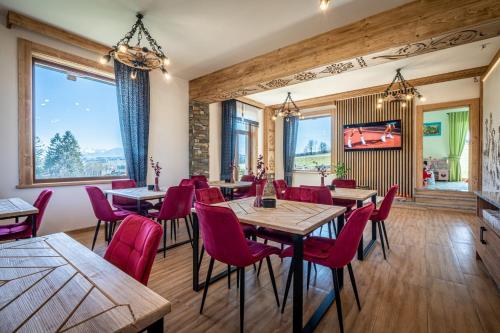 restauracja z drewnianymi stołami i czerwonymi krzesłami w obiekcie Dworek nad Jałowcami w Białym Dunajcu