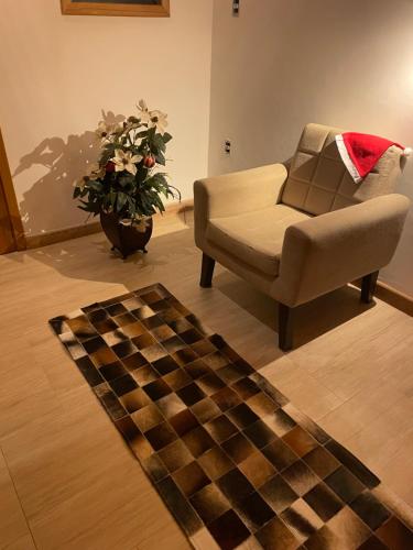 a living room with a couch and a checkered rug at VILLA ITÁLIA CHALÉ in Santo Antônio do Pinhal