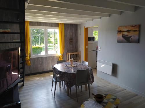 a dining room with a table and a kitchen at Les gîtes de Vensac in Vensac
