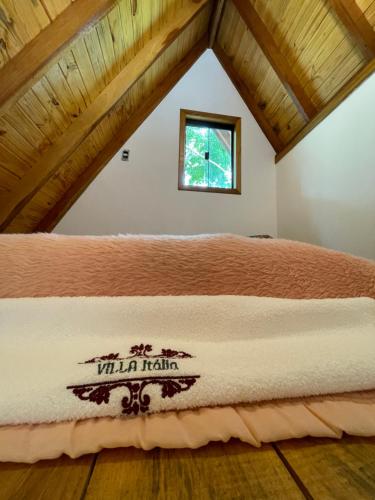 a bed in a room with a wooden ceiling at VILLA ITÁLIA CHALÉ in Santo Antônio do Pinhal