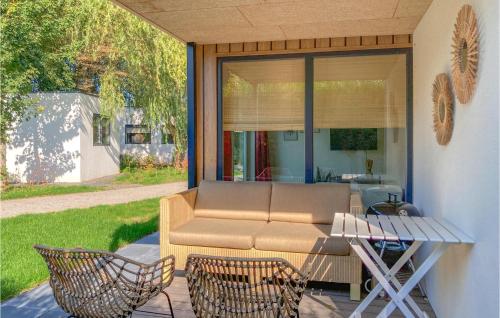 a patio with a couch and chairs and a table at Lovely Home In Heinkenszand With Sauna in Heinkensand