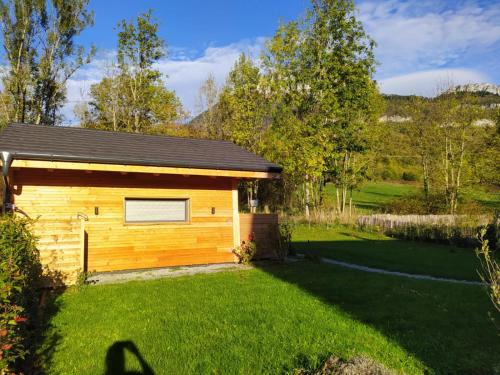 a small wooden cabin with a grass yard at Maisonnette in Talloires