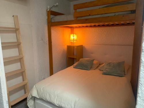a bedroom with a bunk bed with a light on it at Studio de 32 m2 pour 3 personnes pied des pistes in Les Deux Alpes