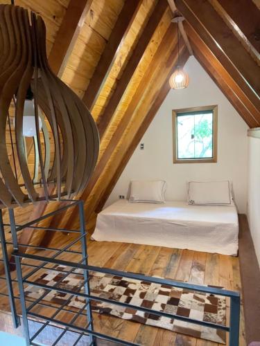 a bedroom with a bed in a attic at VILLA ITÁLIA CHALÉ in Santo Antônio do Pinhal