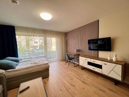 1 dormitorio con 1 cama y TV de pantalla plana en Apartment Beethoven by Aux Property, en Augsburg